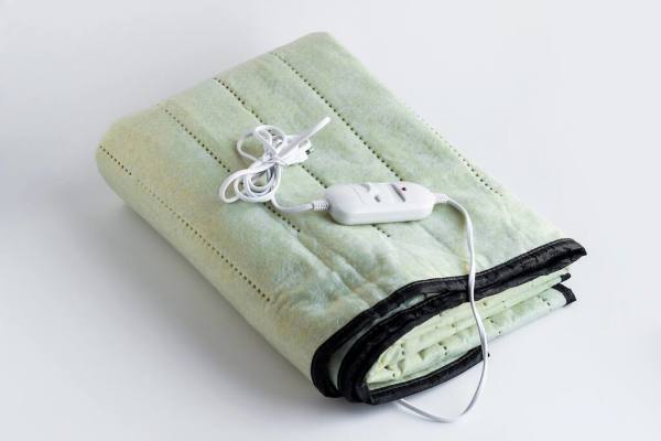 An electric blanket with a control unit on a white background.