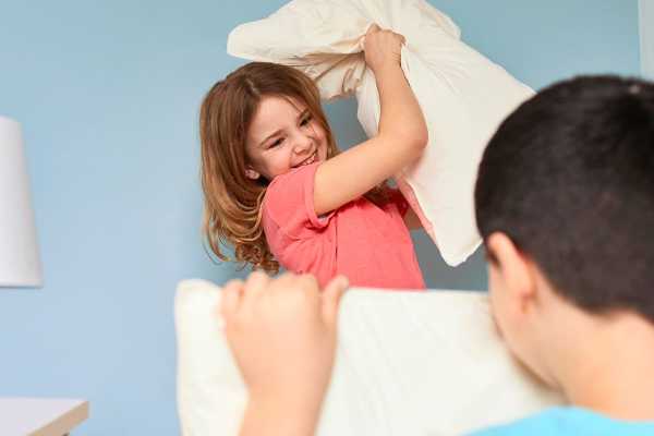 Two children having a pillow fight.