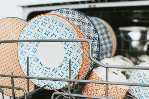 Orange and blue plates stacked in a dishwasher
