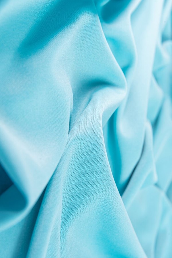 Close-up of light blue fabric with soft folds.