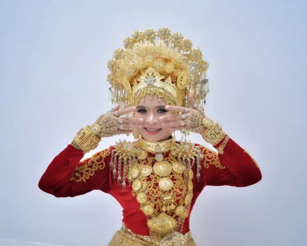 Wanita mengenakan pakaian adat Minangkabau dengan aksesori emas.