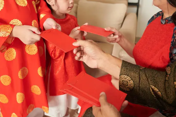 Người lớn đang trao phong bao lì xì cho trẻ em trong dịp lễ.