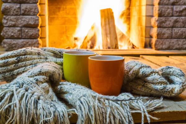 Hai cốc và chiếc khăn len trước lò sưởi.