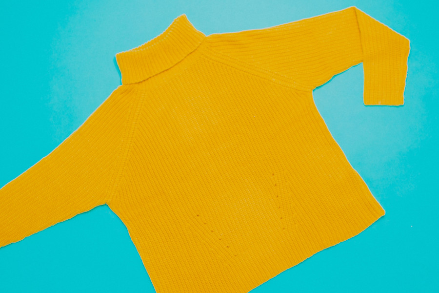 A yellow knitted sweater on a blue background.