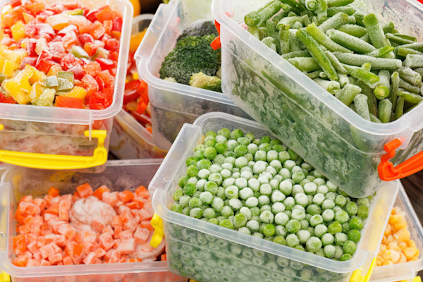 Verschiedene gefrorene Gemüsesorten in Plastikbehältern.