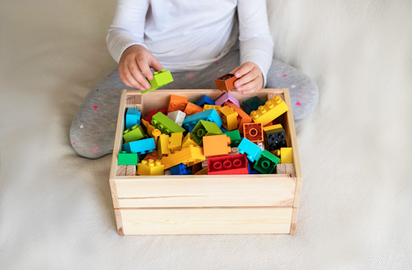 Niño jugando con bloques de construcción de plástico coloridos.