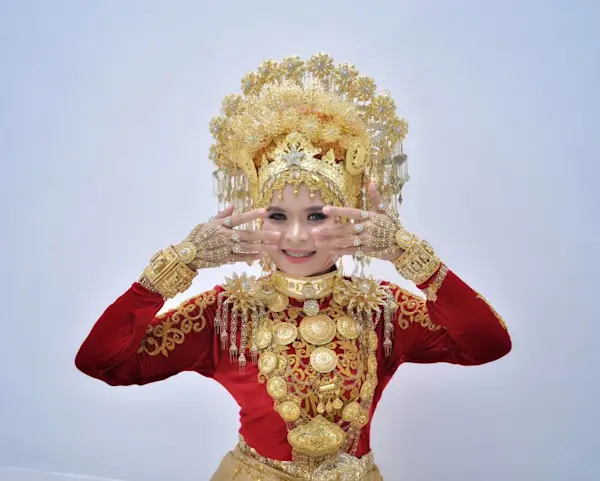 Wanita mengenakan pakaian adat Minangkabau dengan aksesori emas.