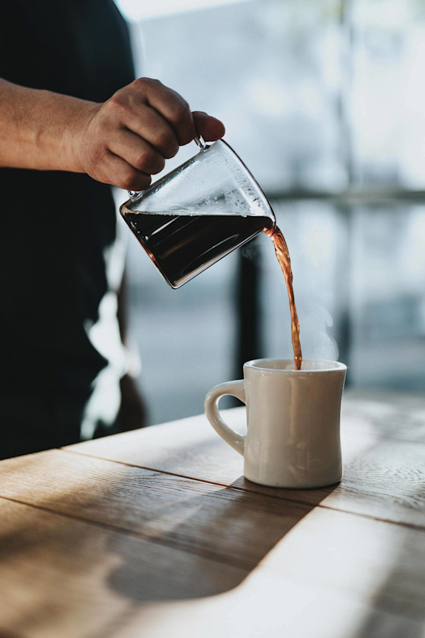 Kaffee wird in eine Tasse gegossen.