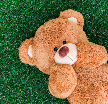 Oso de peluche sobre césped artificial.