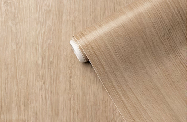 Roll of adhesive wood-effect vinyl lying on a flat surface.