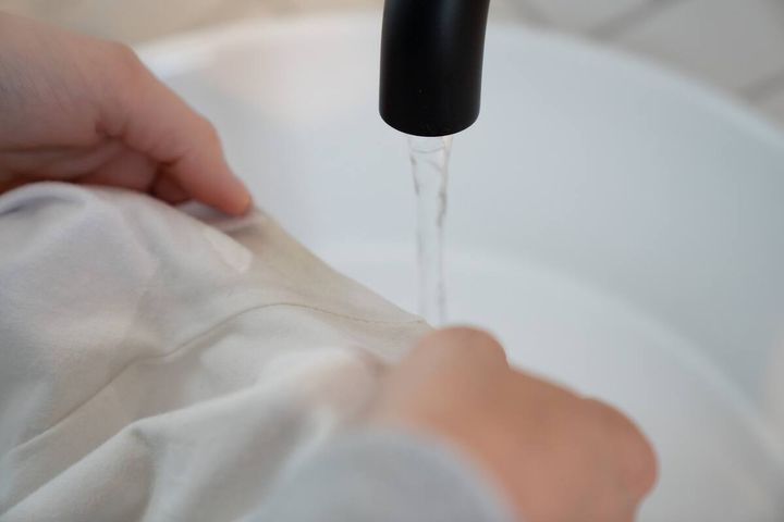 Using water to rinse a stain out of a white garment